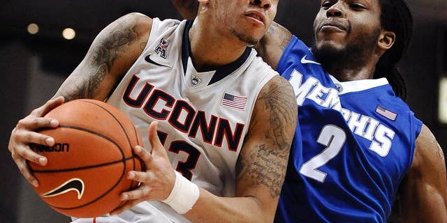 FILE - In this Feb. 15, 2014 file photo, Connecticut's Shabazz Napier, left, drives to the basket as Memphis' Shaq Goodwin defends during the second half an NCAA college basketball game in Hartford, Conn. Napier was selected to The Associated Press All-America team, released Monday, March 31, 2014. (AP Photo/Jessica Hill, FIle)
