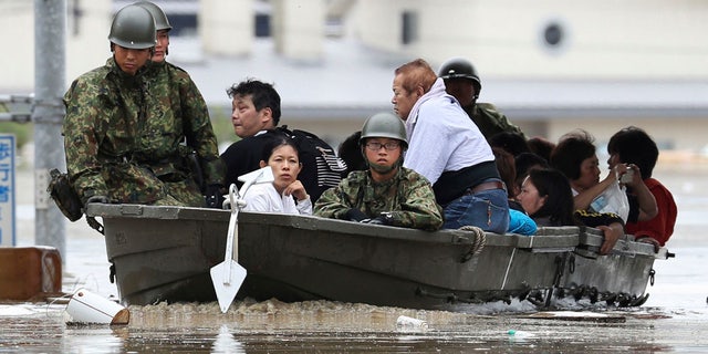 Japan Ground Self-Defense Force members use a boat to evacuate residents from a flooded area caused by heavy rains in Kurashiki, Okayama prefecture