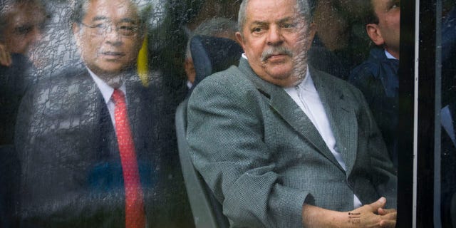 FILE - In this June 6, 2012 file photo, former Brazilian President Luiz Inacio Lula da Silva, right, sits on a bus that is part of a new transportation project in Rio de Janeiro, Brazil. Brazil's attorney general says he will investigate claims that former President Luiz Inacio Lula da Silva knew about a cash-for-votes scheme in Congress. Roberto Gurgel said Wednesday, Dec. 19, 2012 he'll examine statements by businessman Marcos Valerio that Silva approved of the so-called monthly payout scheme and that he used cash from it while in office. (AP Photo/Victor R. Caivano, File)