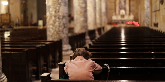 WATERBURY, CT - MAY 20: A woman prays in a Catholic church on May 20, 2013 in Waterbury, Connecticut. Waterbury, once a thriving industrial city with one of the largest brass manufacturing bases in the world, has suffered economically in recent decades as manufacturing jobs have left the area. According to recent census data, 20.6%. of the city's residents are living below the poverty level. (Photo by Spencer Platt/Getty Images)