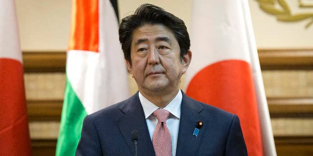 Japanese Prime Minister Shinzo Abe attends a joint press conference with Palestinian President Mahmoud Abbas at the Palestinian Authority headquarters, in the West Bank city of Ramallah, Tuesday, Jan. 20, 2015. An online video released Tuesday purported to show the Islamic State group threatening to kill two Japanese hostages unless they receive a $200 million ransom in the next 72 hours. (AP Photo/Nasser Nasser)