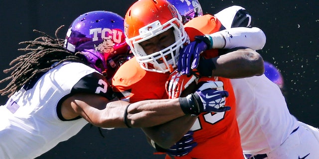 FILE - In this Oct. 19, 2013, file photo, Oklahoma State running back Rennie Childs (23) fights off a tackle by TCU cornerback Jason Verrett (2) and safety Chris Hackett (1) during the fourth quarter of an NCAA college football game in Stillwater, Okla. Childs provided Oklahoma State with a much-needed boost on the ground in last week's win over TCU. The running back could be counted on again this week when the Cowboys travel to Iowa State. (AP Photo/Sue Ogrocki, File)