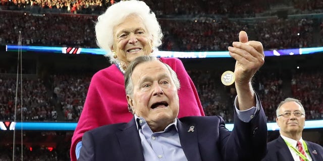 Barbara Bush stands behind her husband, former President George H.W. Bush, as he performs the ceremonial coin toss before Super Bowl 51 in Houston, Texas on Feb. 5, 2017.