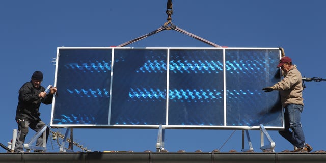 STARNBERG, GERMANY - OCTOBER 15: Workers install solar power modules for producing heat on the roof of a house on October 15, 2011 in Wessling, Germany. Germany has and is continuing to invest heavily in solar energy, both in the public and private sectors. The German government introduced a feed-in tariff with its Renewable Energy Act in 2000 that guarantees homeowners a minimum rate for selling electricity from renewable energy sources into the nation's electricity grid. (Photo by Alexandra Beier/Getty Images)