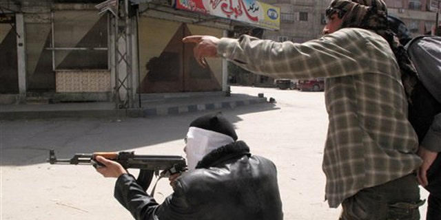 April 6, 2012: In this photo, Free Syrian Army fighters try to spot a sniper during fighting with Syrian troops in a suburb of Damascus, Syria.
