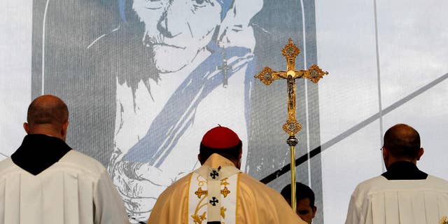 FILE – A portrait of Mother Teresa is pictured behind a crucifix, during a holy Mass dedicated to her on the main square in Skopje, Macedonia, Sunday, Sept 11, 2016. Hundreds of people gathered Sunday at the main square in Macedonian capital Skopje for a ceremony of gratitude dedicated to Mother Teresa who Pope Francis has declared a saint last week in Vatican.