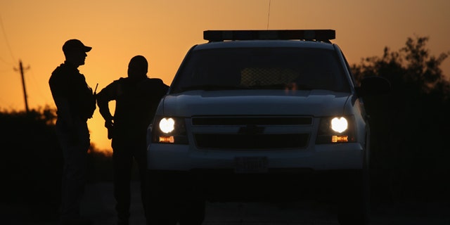 U.S. Border Patrol agents and a pilot from the U.S. Office of Air and Marine on April 11, 2013 in La Joya, Texas.