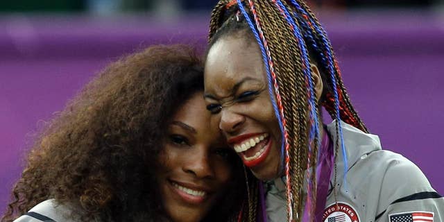 Serena Williams, left, and Venus Williams of the United States celebrate on podium after receiving their gold medals in women's doubles in London.