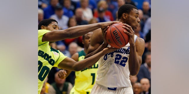 Baylor forward Royce O'Neale (00) tries to take the ball from Kansas guard Andrew Wiggins (22) during the second half of an NCAA college basketball game in Lawrence, Kan., Monday, Jan. 20, 2014. Kansas defeated Baylor 78-68. (AP Photo/Orlin Wagner)