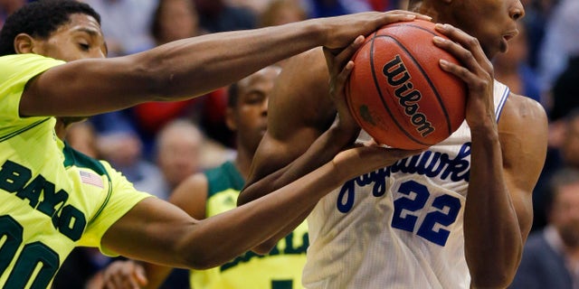 Baylor forward Royce O'Neale (00) tries to take the ball from Kansas guard Andrew Wiggins (22) during the second half of an NCAA college basketball game in Lawrence, Kan., Monday, Jan. 20, 2014. Kansas defeated Baylor 78-68. (AP Photo/Orlin Wagner)