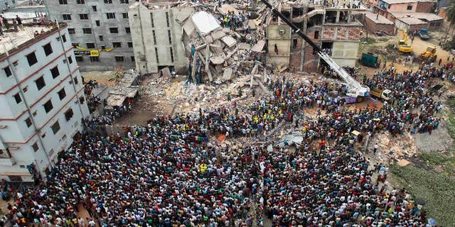 FILE - In this April 25, 2013, file photo, Bangladeshi people gather as rescuers look for survivors and victims at the site of a building that collapsed a day earlier, in Savar, near Dhaka, Bangladesh. A Bangladesh court on Monday, July 18, 2016, indicted 41 people for murder in the 2013 deaths of more than 1,100 people in the collapse of a building that housed five garment factories outside the capital. (AP Photo/A.M.Ahad, File)