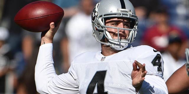 Oakland Raiders quarterback Derek Carr struggles against the pass rush of San Diego Chargers defensive end Corey Liuget during the first half an NFL football game Sunday, Nov. 16, 2014, in San Diego. (AP Photo/Gregory Bull)
