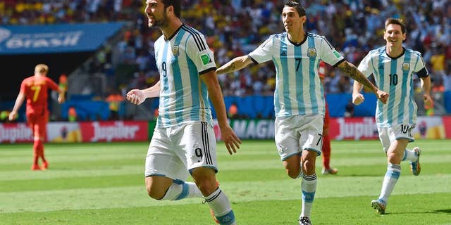 Argentina's Gonzalo Higuain, left, celebrates with Angel di Maria and Lionel Messi, right, after scoring the opening goal during the World Cup quarterfinal soccer match between Argentina and Belgium at the Estadio Nacional in Brasilia, Brazil, Saturday, July 5, 2014. (AP Photo/Martin Meissner)