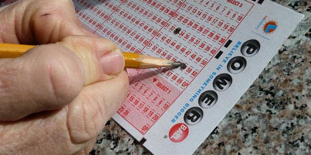 FILE - In this Jan. 12, 2016 file photo, a lottery player fills out numbers on a powerball form in Oakland, Calif. The Powerball jackpot has grown to over 1.5 billion dollars. Only ne ticket matched all six numbers in the drawing Saturday, May 7, for a $429.6 million jackpot, said Powerball spokeswoman Kelly Cripe, and New Jersey lottery officials said Sunday it was sold at a 7-Eleven store in Trenton, N.J. (AP Photo/Ben Margot, File)