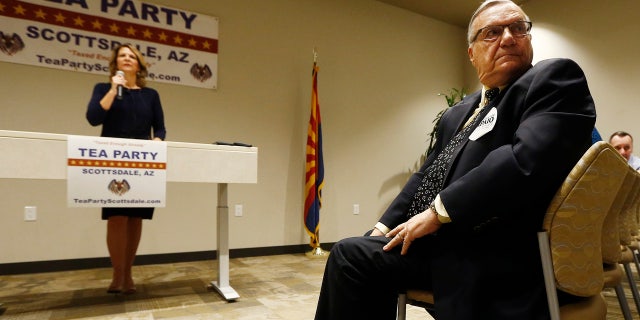 May 17: , Republican Senate candidates Kelli Ward, left, and former Maricopa Country Sheriff Joe Arpaio, right, listen to a question from the audience as the candidates talk about their platform policies at a Scottsdale Tea Party event.