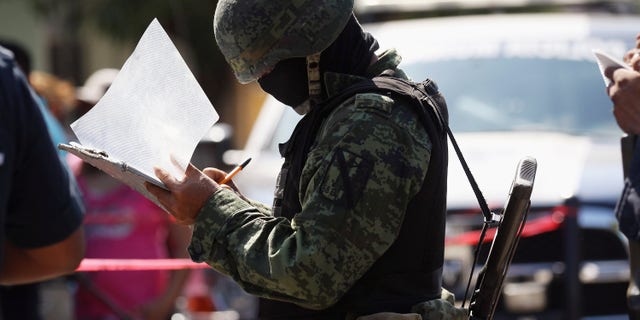 ACAPULCO, MEXICO - MARCH 02: A Mexican army soldier takes notes at the site of a suspected drug-related double execution on March 2, 2012 in Acapulco, Mexico. Drug violence has surged in the coastal resort in the last year, making Acapulco the second most deadly city in Mexico after Juarez. One of Mexico's top tourist destinations, Acapulco has suffered a drop in business, especially from foreign tourists, due to the violence. Toursim accounts for about 70 percent of the economy of Acapulco's state of Guerrero and 9 percent of Mexico's economy. (Photo by John Moore/Getty Images)