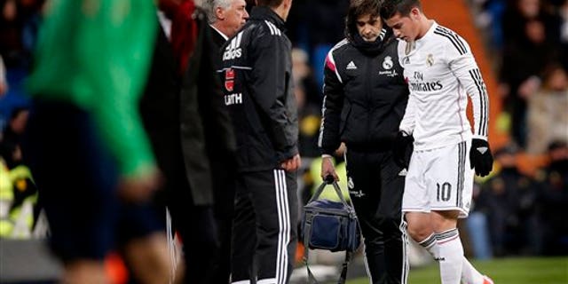 In this Feb. 4, 2015 picture James Rodriguez from Colombia, right, leaves the field injured during a La Liga soccer match between Real Madrid and Sevilla at the Santiago Bernabeu stadium in Madrid, Spain. James Rodriguez will get surgery on his right foot after Real Madrid confirmed a broken a metatarsal bone, who could be out for two or three months. (AP Photo/Daniel Ochoa de Olza)
