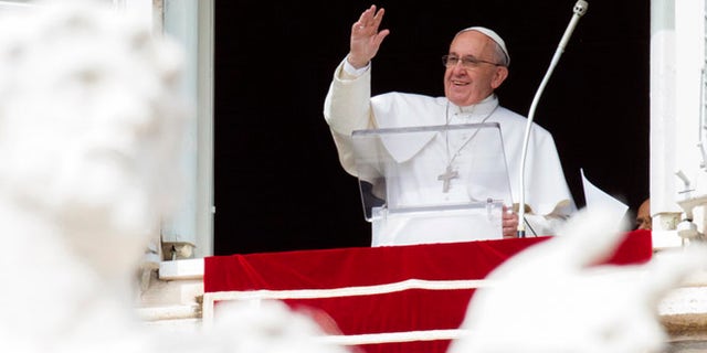 Pope Francis waves to faithful from his studio window overlooking St. Peter's Square, during the Angelus noon prayer at the Vatican, Sunday, Feb. 22, 2015. Francis told tens of thousands of Romans, tourists and pilgrims in St. Peter's Square that later Sunday he and top aides were starting a spiritual renewal retreat. Until Friday morning, they will spend time listening to reflections, meditating and praying in Ariccia, a Rome suburb. (AP Photo/Riccardo De Luca)