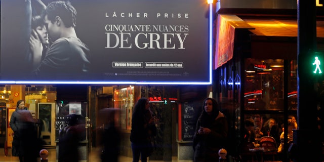 Parisians gather in front of a cinema playing "Fifty Shades of Grey" directed by Sam Taylor-Johnson, inspired by the 2011 erotic romance novel by British author E. L. James, in Paris, France, Wednesday, Feb. 11, 2015. Children as young as 12 are heading to see the highly-anticipated erotic drama âFifty Shades of Greyâ in France on its release Wednesday, after the countryâs film board decided against giving it an adult certificate. (AP Photo/Francois Mori)