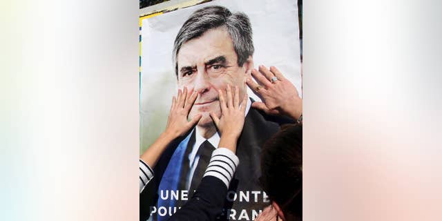 Supporters of conservative presidential candidate Francois Fillon glue a campaign poster in Bayonne, southwestern France, Wednesday, April 19, 2017. The two-round presidential election is set for April 23 and May 7. (AP Photo/Bob Edme)