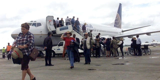 Passengers walk away from a Continental Airlines Boeing-737 at Havana's Jose Marti International Airport. (Photo by Jorge Rey/Getty Images)