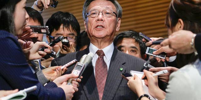 FILE - In this March 4, 2016 file photo, Okinawa Gov. Takeshi Onaga is surrounded by reporters after a meeting with Japanese Prime Minister Shinzo Abe at the latter's official residence in Tokyo. Japan and the U.S. have marked a partial return of the land used by American troops to Okinawa in a ceremony on the southern island Thursday, Dec. 22, 2016, , but there was no sign the move was helping to lessen protests against the heavy U.S. military presence. Demanding an unconditional land return, Okinawa Gov. Onaga skipped Thursday’s ceremony and joined a protest. (Kimimasa Mayama/Pool Photo via AP, File)
