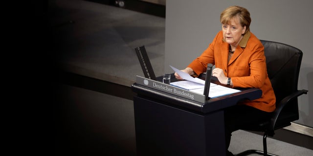 German Chancellor Angela Merkel speaks during a government statement as part of a meeting of the German federal parliament, Bundestag, in Berlin, Germany, Wednesday, Jan. 29, 2014. Due to a hip injury Merkel has to sit during her speech. The reflections are caused by windows at the visitors tribune.  (AP Photo/Michael Sohn)