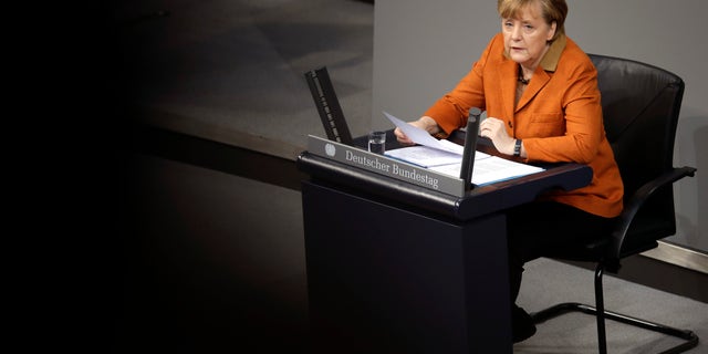German Chancellor Angela Merkel speaks during a government statement as part of a meeting of the German federal parliament, Bundestag, in Berlin, Germany, Wednesday, Jan. 29, 2014. Due to a hip injury Merkel has to sit during her speech. The reflections are caused by windows at the visitors tribune. (AP Photo/Michael Sohn)