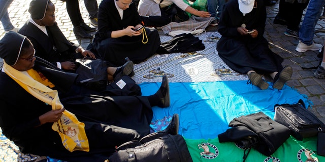 Nuns sit in the area around the ancient Colosseum a few hours ahead of the Way of the Cross procession, in Rome, Friday, April 14, 2017. Thousands of pilgrims are expected to flood the area surrounding the Colosseum to listen to the words of Pope Francis and watch the march leading to the cross. (AP Photo/Andrew Medichini)