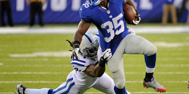 FILE - In this Aug. 18, 2013 file photo, New York Giants running back Andre Brown (35) breaks a tackle by Indianapolis Colts' Lawrence Sidbury (52) during the first half of an NFL preseason football game in East Rutherford, N.J. With Brown about to come off injured reserve, the Giants have three players who could start this weekend against Oakland. (AP Photo/Bill Kostroun, File)
