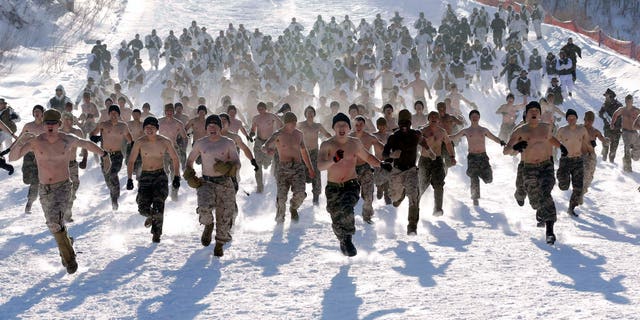 Shirtless South Korean Marines and their U.S. counterparts from 3-Marine Expeditionary Force 1st Battalion from Kaneho Bay, Hawaii, run on a snow covered field during their Feb. 4-22 joint military winter exercise in Pyeongchang.