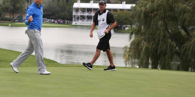 Sergio Garcia, left, of Spain, reacts after sinking his putt on the 18th hole for a birdie during the second round of the BMW Championship golf tournament at Cherry Hills Country Club in Cherry Hills Village, Colo., Friday, Sept. 5, 2014. (AP Photo/Brennan Linsley)