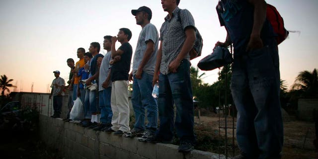 Migrantes centroamericanos esperan de pie afuera de la Casa del Migrante en Arriaga, Chiapas, el viernes 7 de enero del 2011. El tren más usado por los migrantes en su camino de este estado del sur de México hacia Estados Unidos no llegó el viernes a Arriaga y las autoridades locales hicieron un operativo sorpresa para escoltar a los migrantes a la frontera con el estado de Oaxaca. De acuerdo con varias organizaciones defensoras de los derechos de los migrantes, las autoridades detuvieron el tren en Oaxaca para sabotear una protesta programada para el viernes a bordo del tren. (Foto AP/Miguel Tovar)