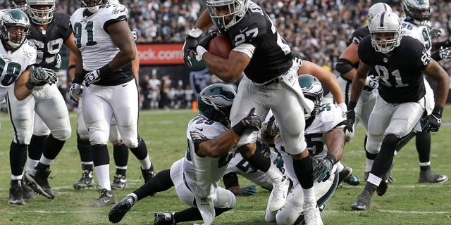 Oakland Raiders running back Rashad Jennings (27) runs for an 8-yard touchdown against the Philadelphia Eagles during the second quarter of an NFL football game in Oakland, Calif., Sunday, Nov. 3, 2013. (AP Photo/Marcio Jose Sanchez)