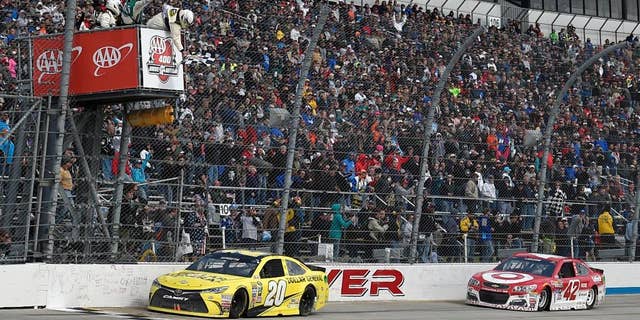 Matt Kenseth (20) takes the checkered flag ahead of Kyle Larson (42) to win the NASCAR Sprint Cup series auto race, Sunday, May 15, 2016, at Dover International Speedway in Dover, Del. (AP Photo/Nick Wass)