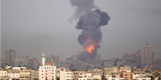 Explosion and smoke rise following an Israeli strike in Gaza, seen from the Israel Gaza Border, southern Israel, Saturday, Nov. 17, 2012. Israel bombarded the Hamas-ruled Gaza Strip with more than 180 airstrikes early Saturday, the military said, widening a blistering assault on militant operations to include the prime minister's headquarters, a police compound and a vast network of smuggling tunnels. The new attacks followed an unprecedented rocket strike aimed at the contested holy city of Jerusalem that raised the stakes in Israel's violent confrontation with Palestinian militants. (AP Photo/Ariel Schalit)