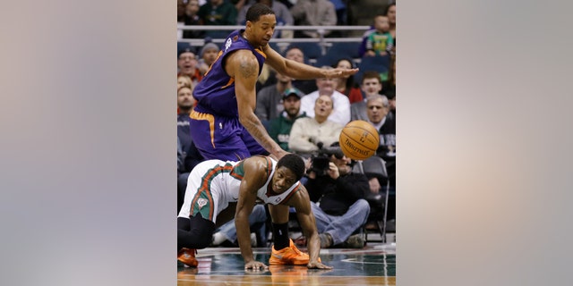 Milwaukee Bucks' Brandon Knight, bottom, and Phoenix Suns' Channing Frye watch a loose ball during the first half of an NBA basketball game Wednesday, Jan. 29, 2014, in Milwaukee. (AP Photo/Jeffrey Phelps)