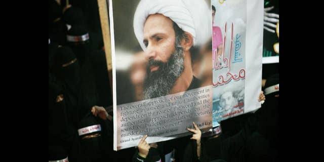 FILE - In this Sunday, Sept. 30, 2012 file photo, a Saudi anti-government protester carries a poster with the image of jailed Shiite cleric Sheik Nimr al-Nimr during the funeral of three Shiite Muslims allegedly killed by Saudi security forces in the eastern town of al-Awamiya, Saudi Arabia. Mohammed al-Nimr, the brother of Nimr al-Nimr said Wednesday, Oct. 15, 2014, on Twitter that his brother has been sentenced to death by a court in Saudi Arabia. Shiite activist Jaafar al-Shayeb in eastern Saudi Arabia says the verdict appears to have been handed down for criminal offenses over the "incitement" of Shiite protests in Saudi Arabia and neighboring Bahrain. The headbands read, "martyrdom is honor and dignity." (AP Photo, File)