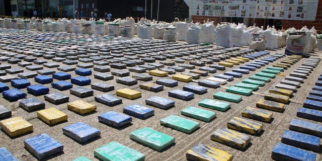 This photo released by Colombia's National Police shows packages of cocaine on display in Necocli, in the northwestern state of Antioquia, Colombia, Sunday, May 15, 2016. The National Police agency said commandos backed by helicopters seized about eight tons of cocaine on a banana plantation belonging to a gang known as the Clan Usuaga and was apparently destined for the Caribbean and then to the United States. Authorities say its the biggest cocaine seizure in Colombia's history. (Colombia National Police via AP)