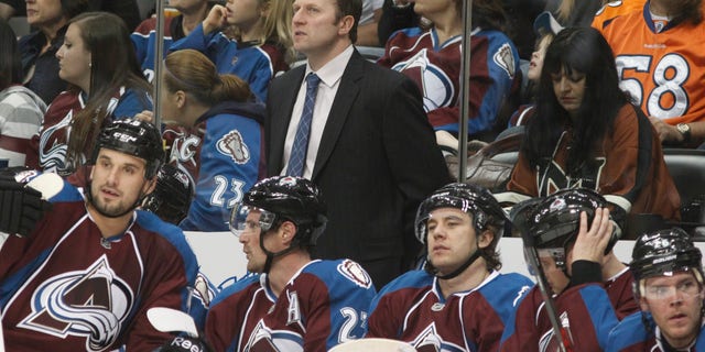 Colorado Avalanche head coach Joe Sacco, back, looks on as his players take a break during a time out against the Minnesota Wild in the second period of an NHL hockey game in Denver on Saturday, April 27, 2013. (AP Photo/David Zalubowski)