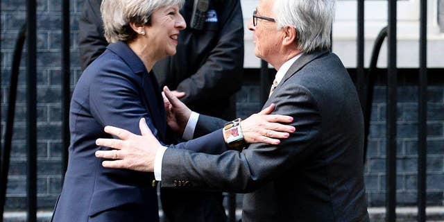 FILE - In this April 4, 2017 file photo, Britain's Prime Minister Theresa May greets European Commission President Jean-Claude Juncker outside 10 Downing Street in London. Theresa May acknowledged Tuesday May 2, 2017 that Brexit "will not be easy," after EU officials accused Britain of underestimating the complexity of the task ahead. (John Stillwell/PA via AP)