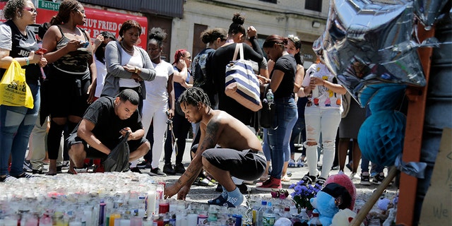 People leave candles and other mementos at a memorial to Lesandro Guzman-Feliz near the site of his murder in the Bronx borough of New York.