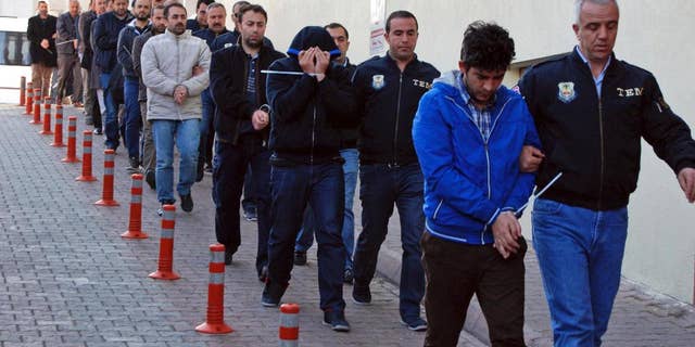Police officers escort people, arrested because of suspected links to U.S.-based cleric Fethullah Gulen, in Kayseri, Turkey, Wednesday, April 26, 2017. Police launched simultaneous operations across the country on Wednesday, detaining hundreds of people with suspected links to U.S.-based cleric Fethullah Gulen. The suspects are allegedly Gulen operatives who directed followers within the police force. (Olay Duzgun/DHA-Depo Photos via AP)