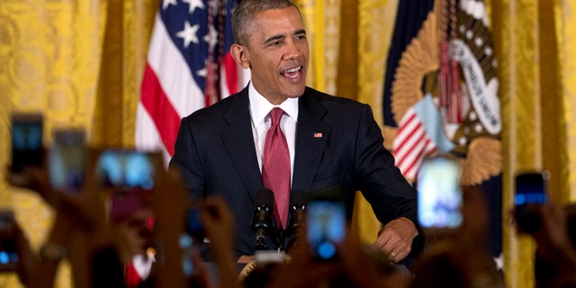 Audience members hold their cell phones high as President Barack Obama speaks during a Cinco de Mayo reception in the East Room of the White House in Washington, Tuesday, May 5, 2015. Obama says that when it comes to achieving a comprehensive overhaul of immigration laws progress is 'not always a straight line.' He says that despite his executive actions on immigration, Congress still needs to pass legislation to make more permanent changes. (AP Photo/Carolyn Kaster)