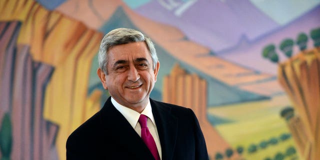Armenian President Serge Sarkisian smiles as he casts his ballot during presidential election in Yerevan, Armenia Monday, Feb. 18, 2013. Armenian President Serge Sarkisian was re-elected for a second term in the first round of the ex-Soviet nation's presidential election, according to an exit poll Monday.The poll of 19,130 voters conducted by Gallup International and carried by ArmNews TV showed Sarkisian winning 58 percent of Monday's ballot. (AP Photo/PanARMENIAN Tigran Mehrabyan)
