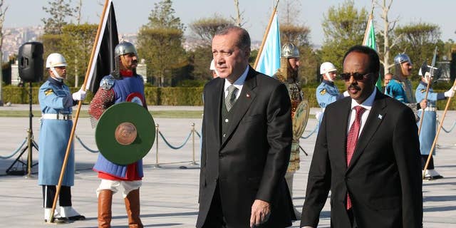 Turkey's President Recep Tayyip Erdogan, centre, walks with Somalia's President Mohamed Abdullahi Mohamed, also known as Farmajo, right, during a welcome ceremony at the Presidential palace in Ankara, Turkey, Wednesday, April, 26, 2017. Mohamed is in Turkey for an official visit. (Presidency Press Service via AP, Pool)