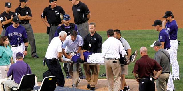 Colorado Rockies starting pitcher Juan Nicasio is surrounded by teammates and medical personnel on his way off the field after Washington Nationals' Ian Desmond hit him in the head with a line drive during the second inning of a baseball game Friday, Aug. 5, 2011 in Denver. (AP Photo/Barry Gutierrez)