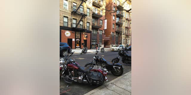 FILE- In this Dec. 16, 2016 file photo, motorcycles are parked on the street outside the Hells Angels motorcycle club headquarters in New York. Authorities said that a man affiliated with the Hells Angels was charged Wednesday, Dec. 21, 2016 in a shooting sparked by a dispute over a parking spot outside the motorcycle club's headquarters on Dec. 11. (AP Photo/Tom Hays, File)