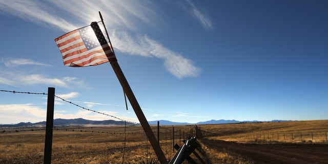 SONOITA, AZ - FEBRUARY 26:  An American flag flies at the U.S.-Mexico border on February 26, 2013 near Sonoita, Arizona. The Federal government has increased the Border Patrol presence in Arizona, from some 1,300 agents in the year 2000 ro 4,400 in 2012. The apprehension of undocumented immigrants crossing into the U.S. from Mexico has declined during that time from 600,016 in 2000 to 123,000 in 2012.  (Photo by John Moore/Getty Images)