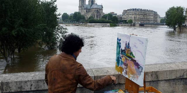 A man paints Notre Dame in Paris, in June 2016.